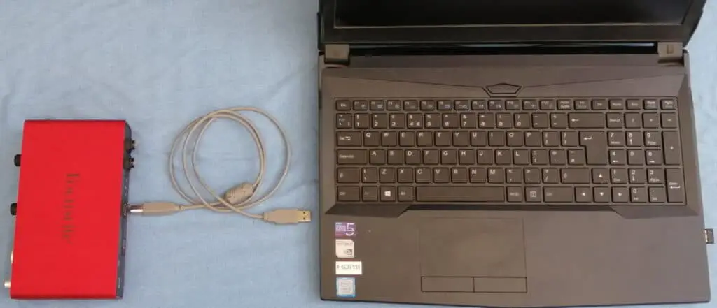 Photo of an audio interface, USB cable and laptop computer