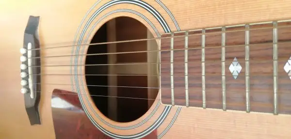 Photo of the fingerboard, soundhole and bridge of an acoustic dreadnought style guitar