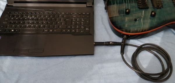 Photo of an electric guitar directly connected to a laptop