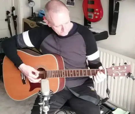 Photo of a guitar player recording an acoustic guitar
